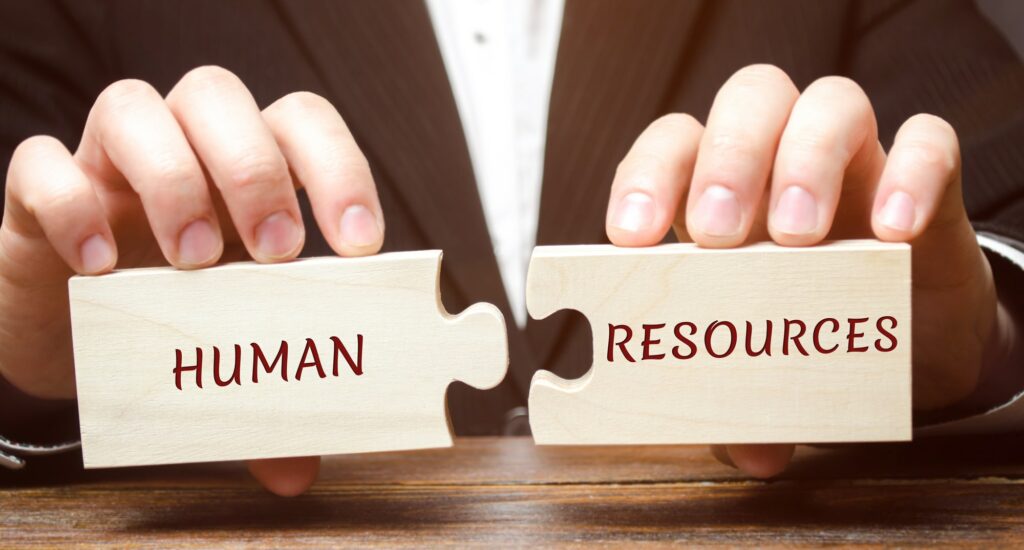 Businessman collects wooden puzzles with the word Human resources