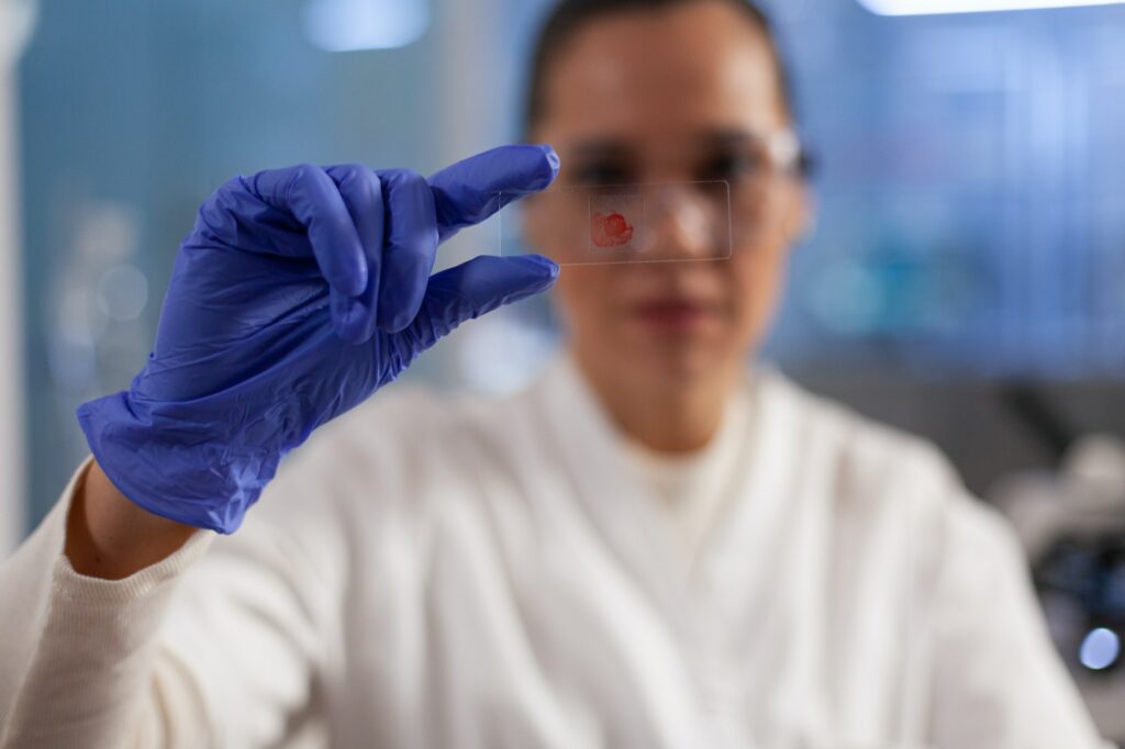 Chemist doctor holding medical slice analyzing blood sample