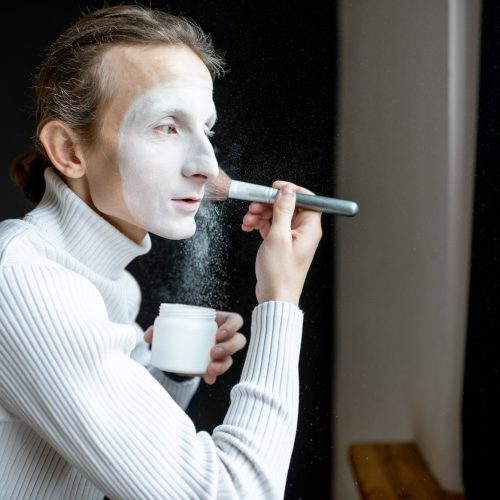 Actor applying makeup on his face