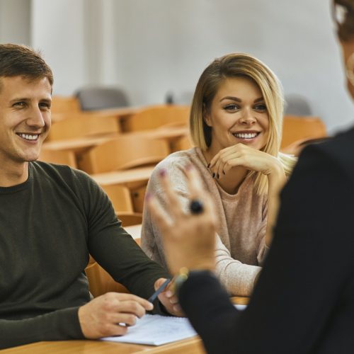 Smiling students and lecturer in auditorium at university