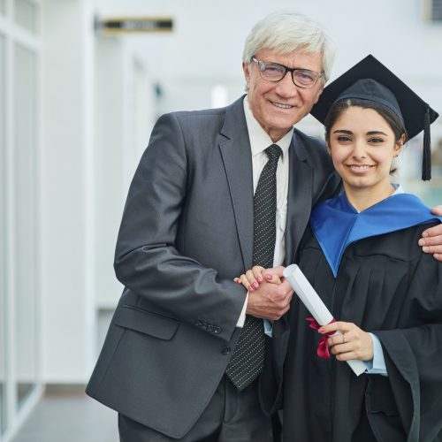Young woman posing with professor at graduation